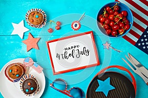 Happy Independence Day, 4th of July celebration concept with frame, cupcakes and barbeque grill  on wooden background