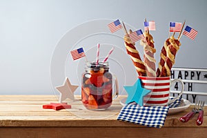 Happy Independence Day, 4th of July celebration concept with summer fresh fruit drink, twisted hot dog sausages and USA flag on