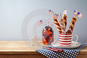 Happy Independence Day, 4th of July celebration concept with summer fresh fruit drink, twisted hot dog sausages and USA flag on