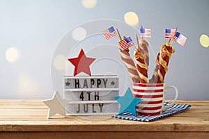 Happy Independence Day, 4th of July celebration concept with twisted hot dog sausages and USA flag on wooden table