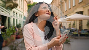 Happy Indian Arabian woman girl businesswoman crossed fingers praying wishing gesture looking mobile phone business