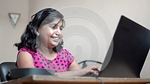 Happy indian asian caucasian girl with short hairs video calling on laptop smiling laughing having fun time. Close up side view sh