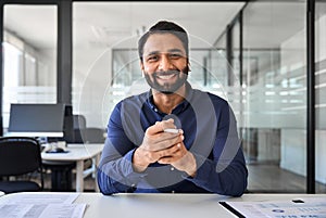 Happy Indian business man having hybrid meeting online in office. Portrait.