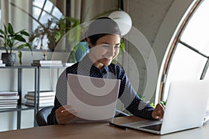 Happy Indian business woman, office employee reviewing paper contract