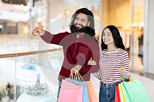 Happy Indian Couple Doing Shopping In Mall Together