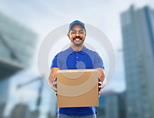 Happy indian delivery man with parcel box in blue