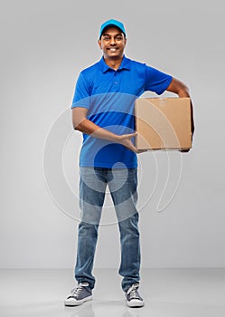 Happy indian delivery man with parcel box in blue