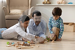 Happy Indian family with small son play toys at home