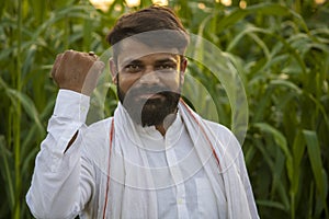 Happy Indian farmer in front of fodder field