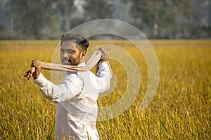 Happy Indian farmer walking in field