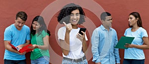 Happy indian female student with phone and group of multi ethnic young adults