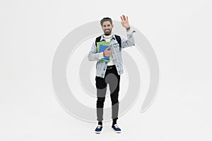 Happy indian male student holding folder and showing greeting gesture isolated on a white background