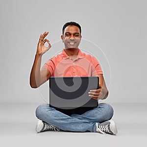 Happy indian man with laptop computer showing ok