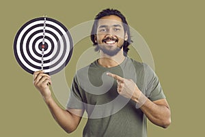 Happy Indian man setting goal, showing shooting target and pointing finger at bullseye