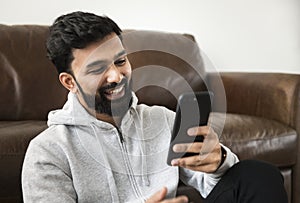 Happy indian man using mobile phone