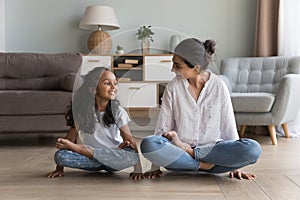 Happy Indian mom and daughter doing yoga together at home
