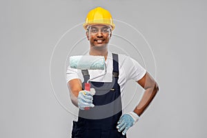 Happy indian painter or builder with paint roller