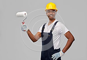 Happy indian painter or builder with paint roller
