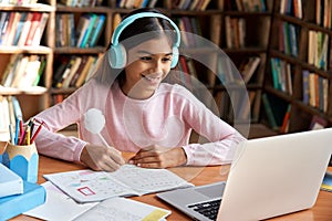 Happy indian school girl learning online class on video zoom call on laptop.