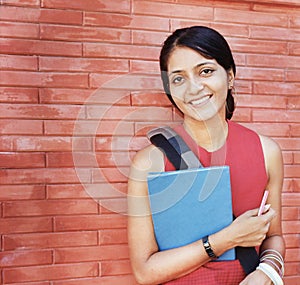 Happy Indian Student smiling with books.