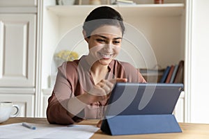Happy indian woman using digital computer tablet.