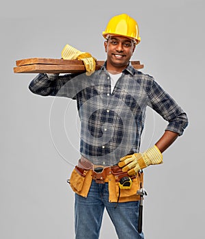 Happy indian worker or builder with wooden boards