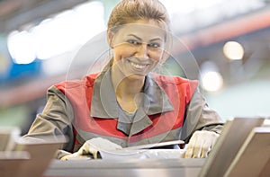 Happy industrial female worker on manufacture workshop background