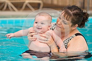 Happy infant baby boy enjoying his first swim