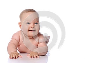 Happy infant child baby girl kid in diaper lying on her tummy, stomach, crawling, touching floor at copy space