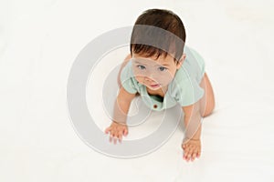 happy infant crawling on floor inside baby playpen