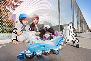 Happy inline-skaters sitting on the floor outdoors