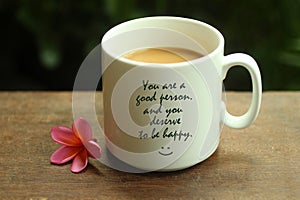 Happy Inspirational quote - You are a good person and you deserve to be happy. With white mug of coffee and self notes on it.