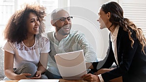 Happy international couple consulting with female realtor