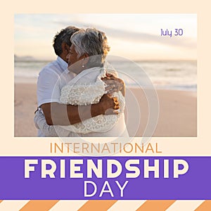 Happy international friendship day text with happy diverse senior couple embracing on sunset beach