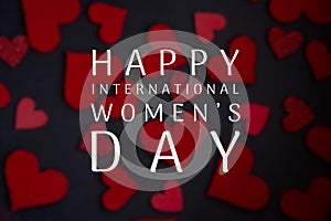 Happy International Women`s Day lettering with white text on black background with red heart