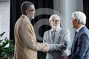 happy interracial business partners shaking hands