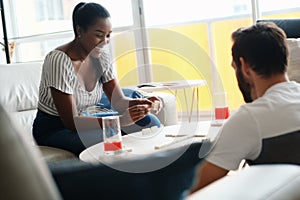 Happy Interracial Couple Having Fun Playing Domino At Home