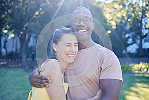 Happy interracial couple, hug and laughing in joy for bonding relationship together in the park. Man hugging woman