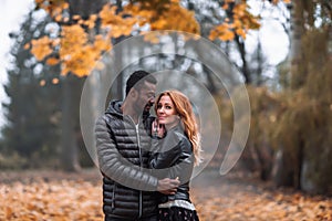 Happy Interracial couple posing in blurry autumn park background