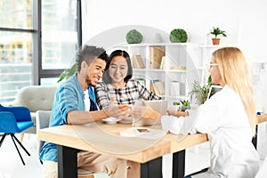 Happy interracial couple with real estate agent in office photo