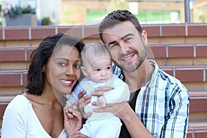 Happy interracial family is celebrating, laughing and having fun with Hispanic African American Mother photo