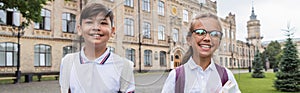 Happy interracial schoolkids with backpacks standing