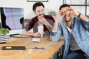 Happy investor with gold BitCoin coins while buying virtual money with friend