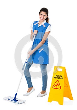 Happy Janitor Mopping By Caution Wet Floor Sign