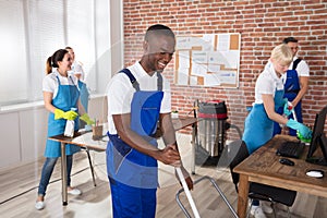 Happy Janitors Cleaning The Office