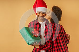 Happy and joyful afro couple exchange christmas present