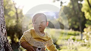 Happy joyful Asia Chinese little boy toddler child enjoy Spring have fun outside embrace nature outdoor carefree childhood meadow