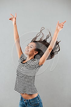 Happy joyful asian woman with flying hair standing