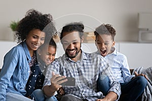 Happy joyful Black family with beloved preschool kids taking selfie