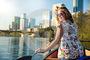 Happy, joyful, cheerful young woman in sunglasses enjoying a hot summer day with water activities, boating, kayaking, and canoeing